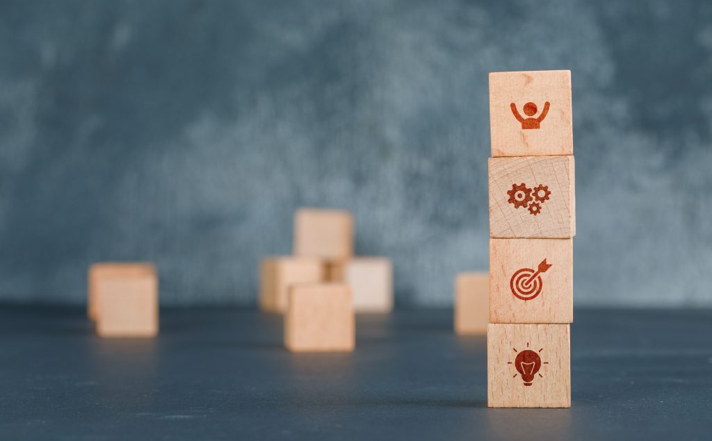 Conceptual of business with wooden blocks column with icons on dark color background side view